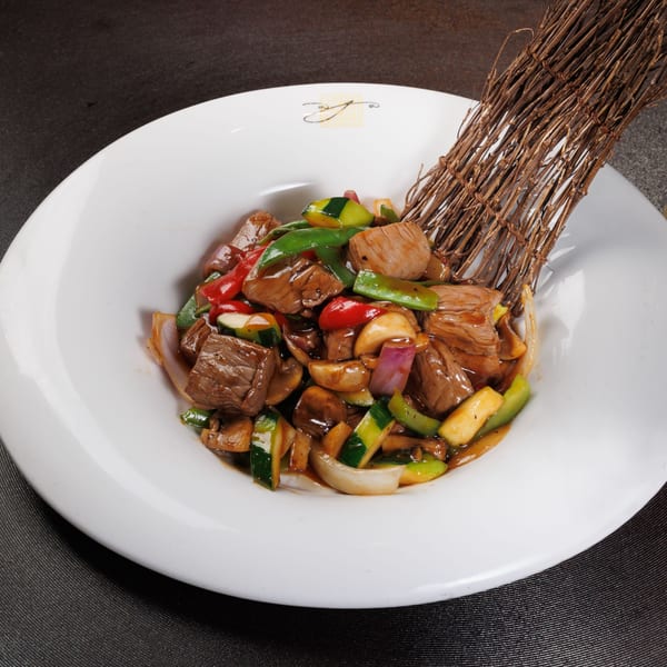 Aja Asian Cuisine's beef stir-fry with colorful vegetables and mushrooms in a white bowl.