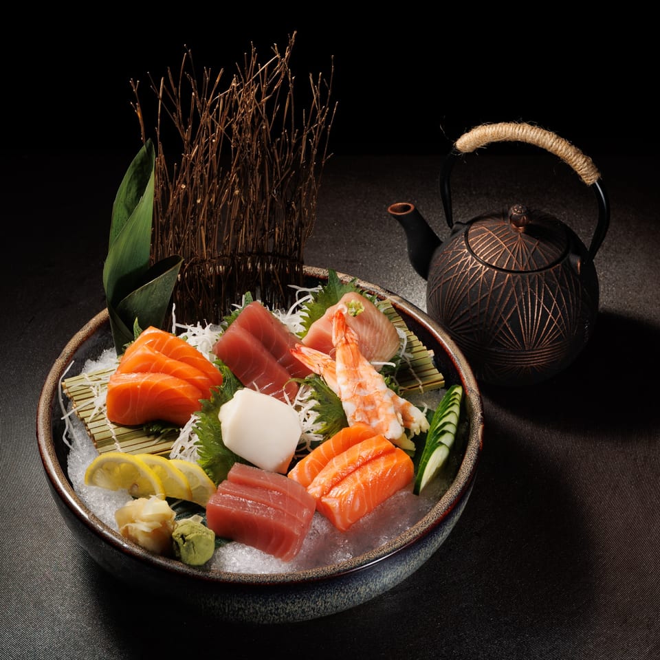 Aja Asian Cuisine & Lounge's sashimi platter with salmon, tuna, shrimp, and squid, served with a teapot.