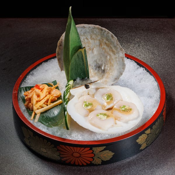 Aja Asian Cuisine's scallops and bamboo shoots served on ice in a decorative black and red bowl.