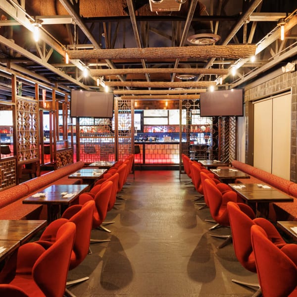 Aja Asian Cuisine & Lounge dining room with red chairs, wooden tables, and decorative screens.